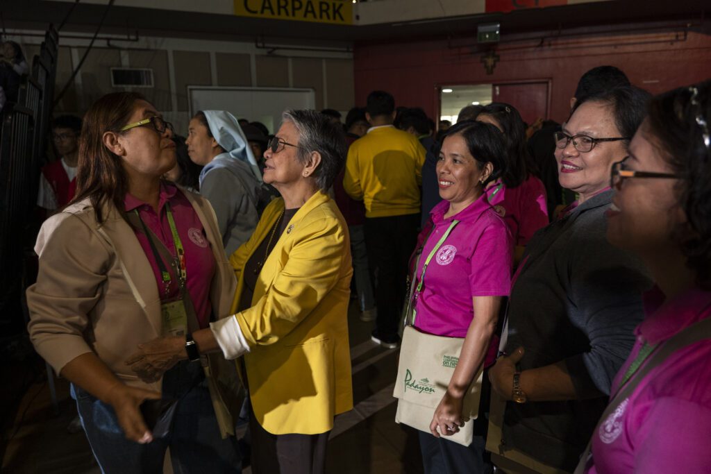 Human rights advocate Edith Burgos is greeted by participants of the 11th Philippine Conference on the New Evangelization (PCNE) after her conversation with Cardinal Luis Antonio Tagle at the University of Santo Tomas in Manila on July 18, 2025. Photo by Mark Saludes